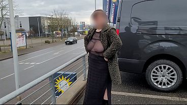 A milf with a sheer top exposed her big tits in the street.